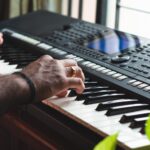 person playing black and white electric keyboard