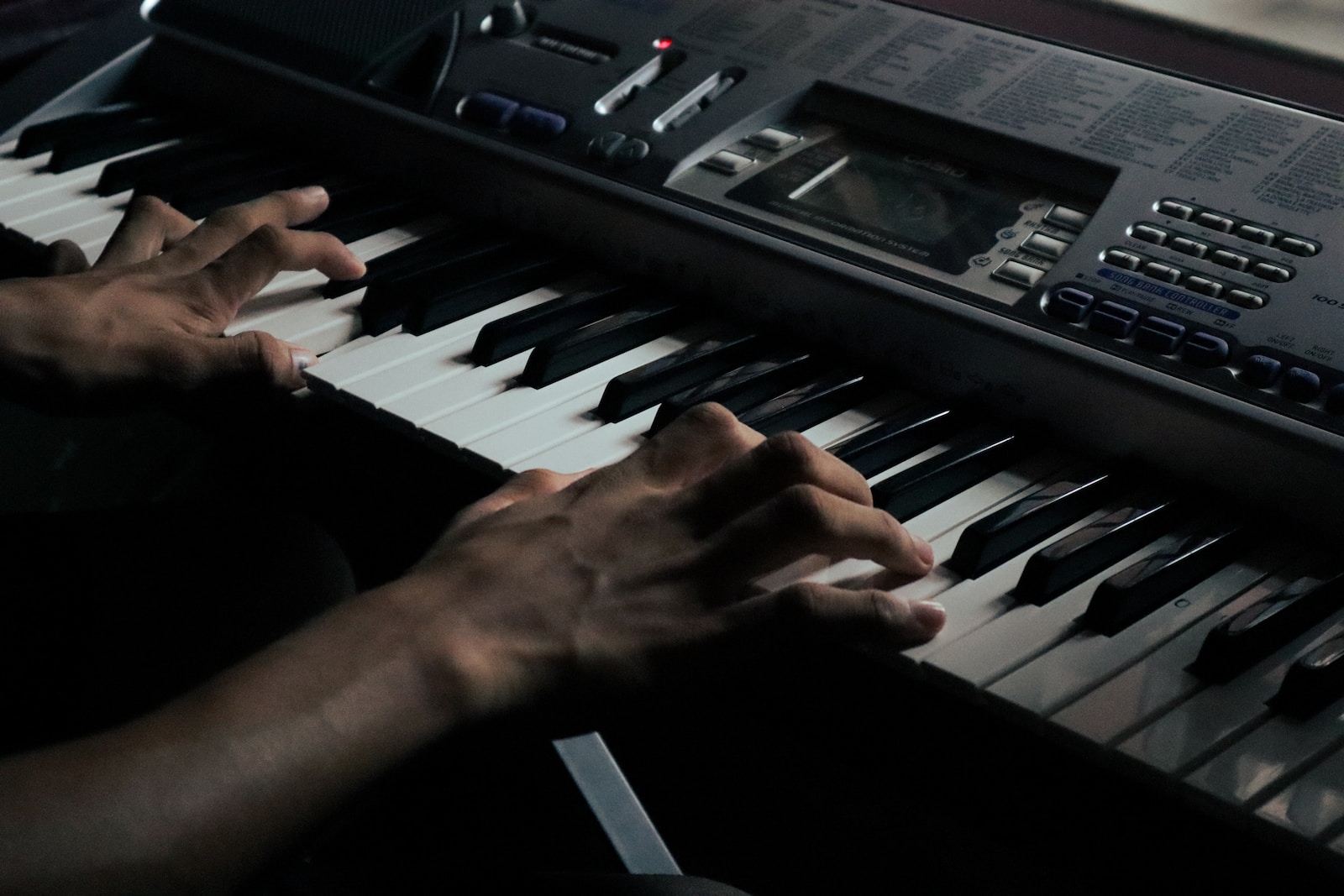 a person playing a keyboard with their hands
