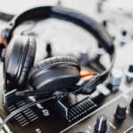 black and gray corded headphones on black and gray audio mixer