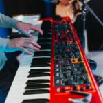 person playing red and black electric keyboard