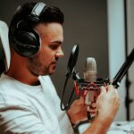 man in white crew neck t-shirt holding microphone